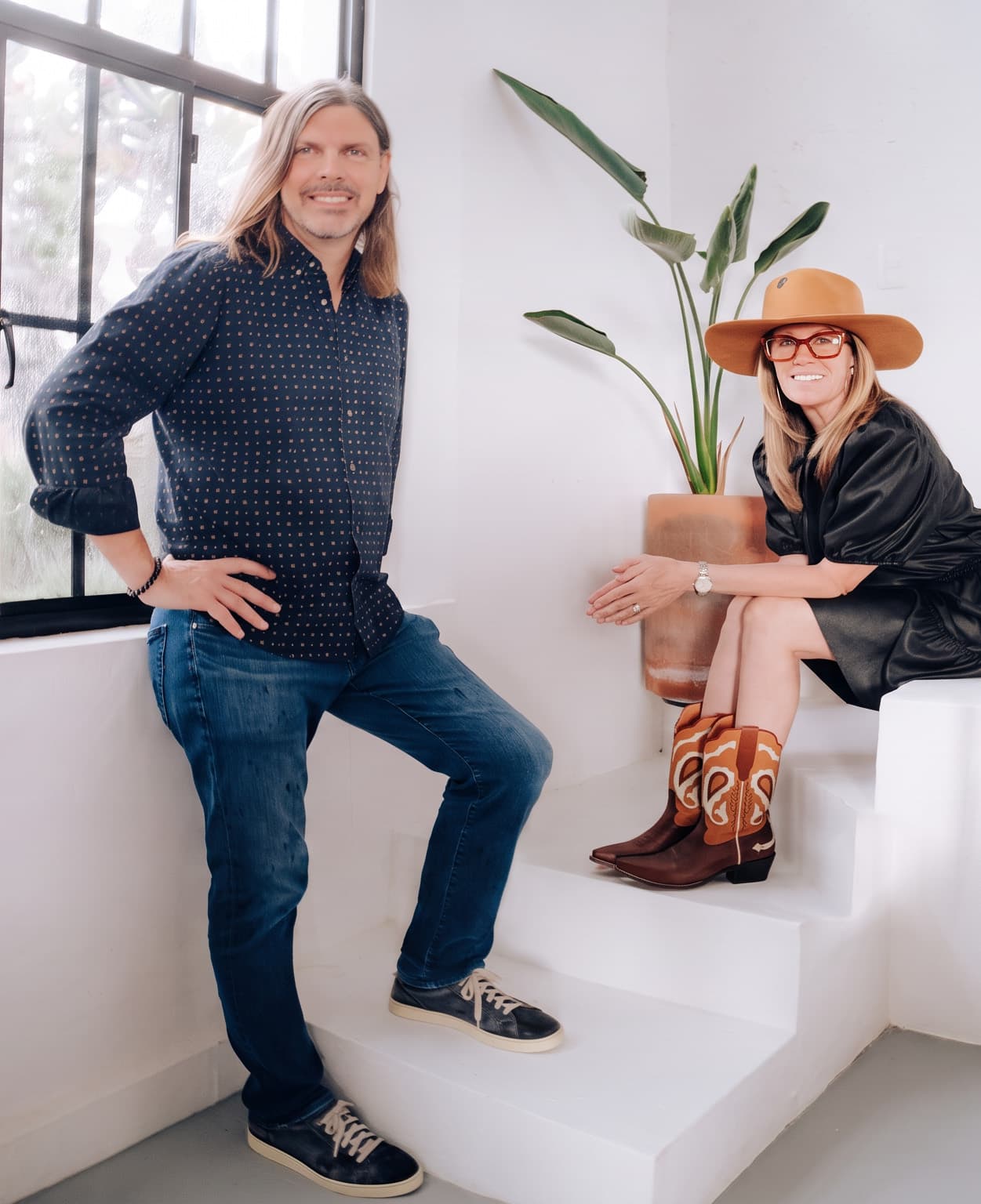 Tiffany Paige and Mike Biersma on white steps beside a studio window