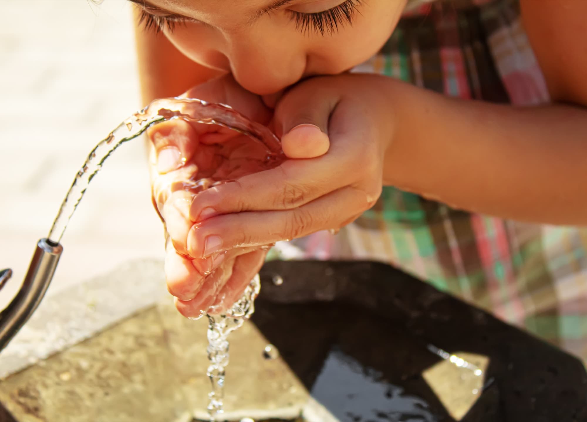 A child drinks from an outdoor fountain, San Miguel de Allende