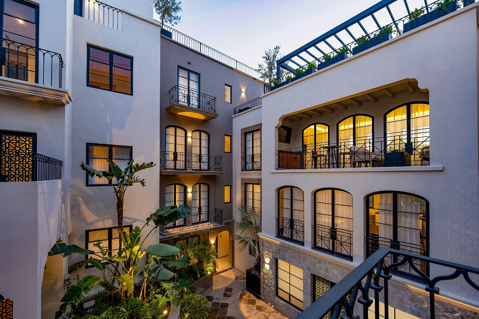 3 · Luxury Penthouse 2 Bedrooms with Private Rooftop - Paseo del Centro — Centro, San Miguel de Allende — photo 21 — elegant courtyard glows warmly at dusk