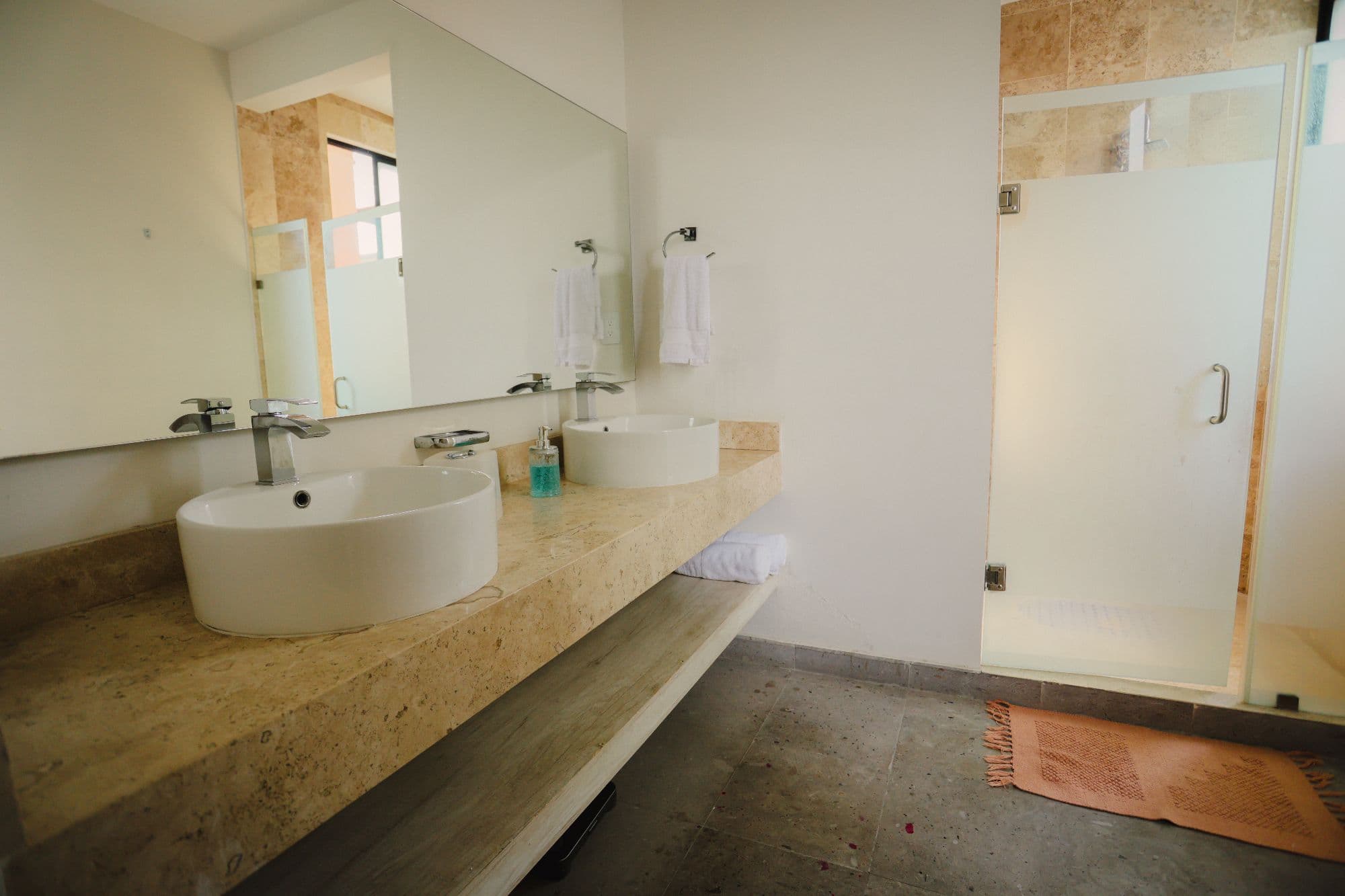 El Milagro Rooftop Apartment — San Miguel de Allende Centro, San Miguel de Allende — photo 2 — spa-like master bath with travertine elegance
