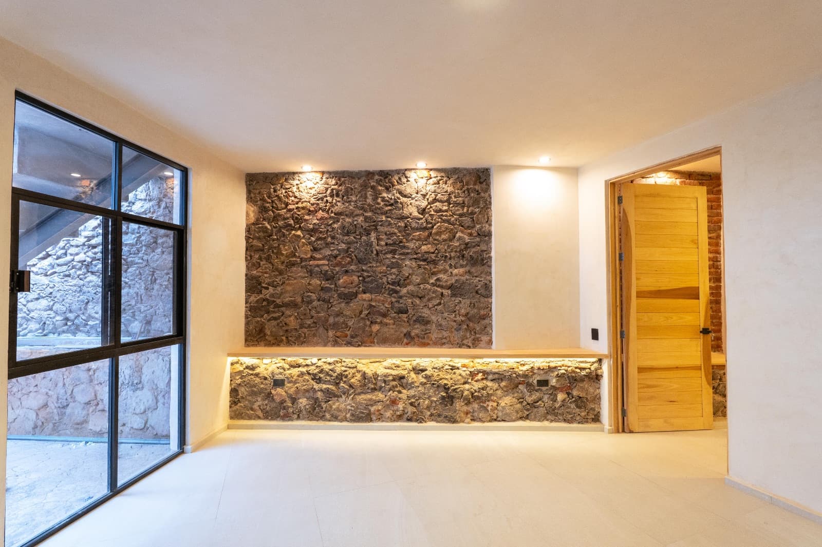Nuñez Lofts / Loft 2 — Centro, San Miguel de Allende — photo 3 — sophisticated stone accent wall, ambient lighting