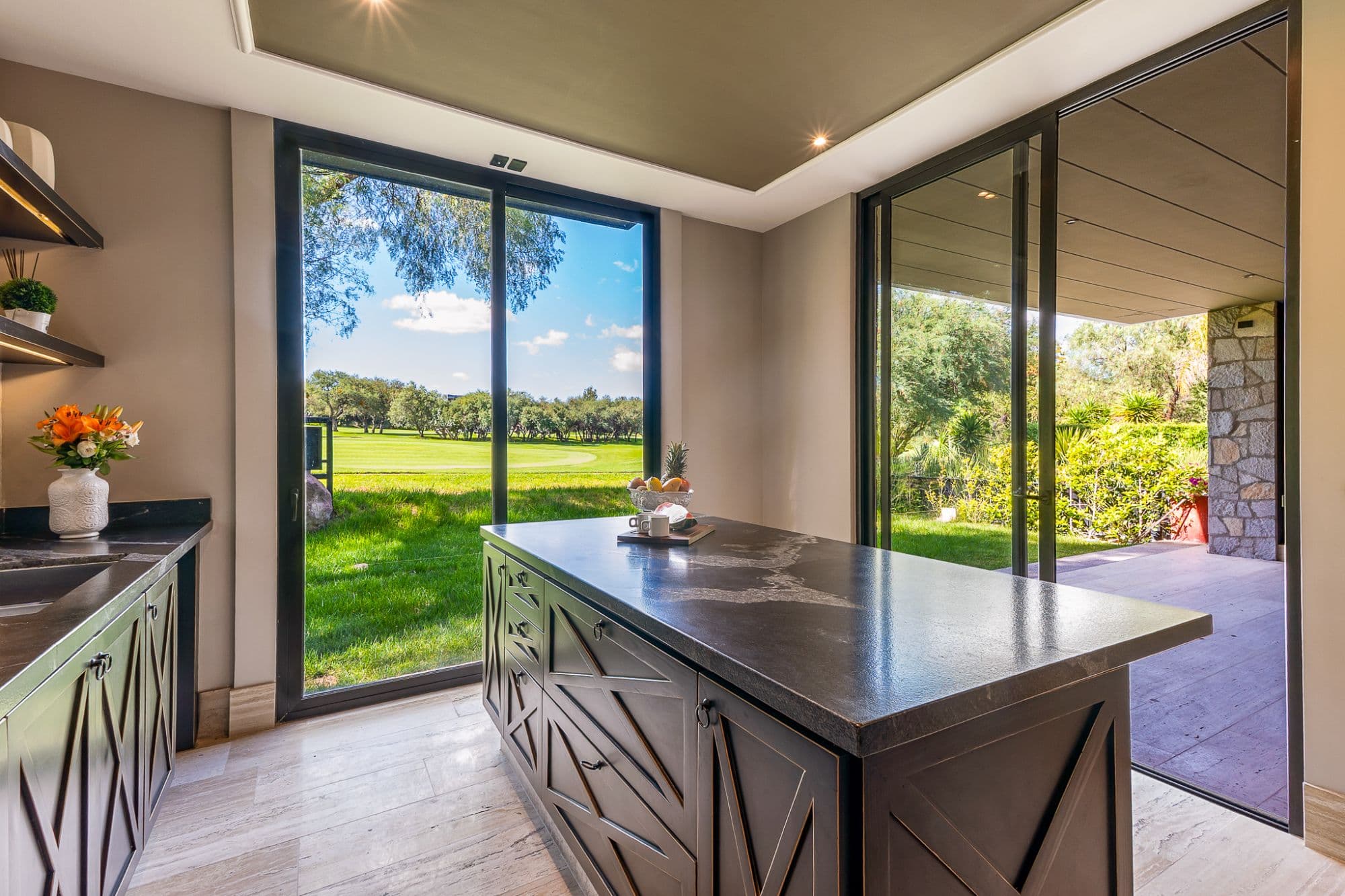 Casa Fairway 7 — Club de Golf Ventanas, San Miguel de Allende — photo 3 — sophisticated kitchen opens to verdant grounds