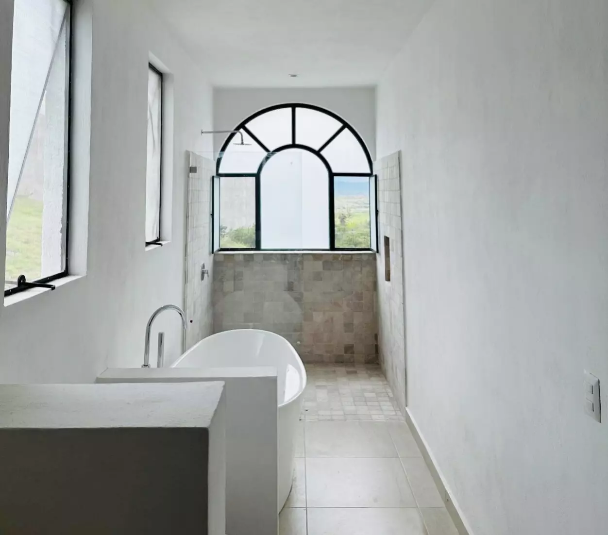 CASA LEO — Residencial Malanquin la Mesa, San Miguel de Allende — photo 9 — luminous bathroom with architectural arched window