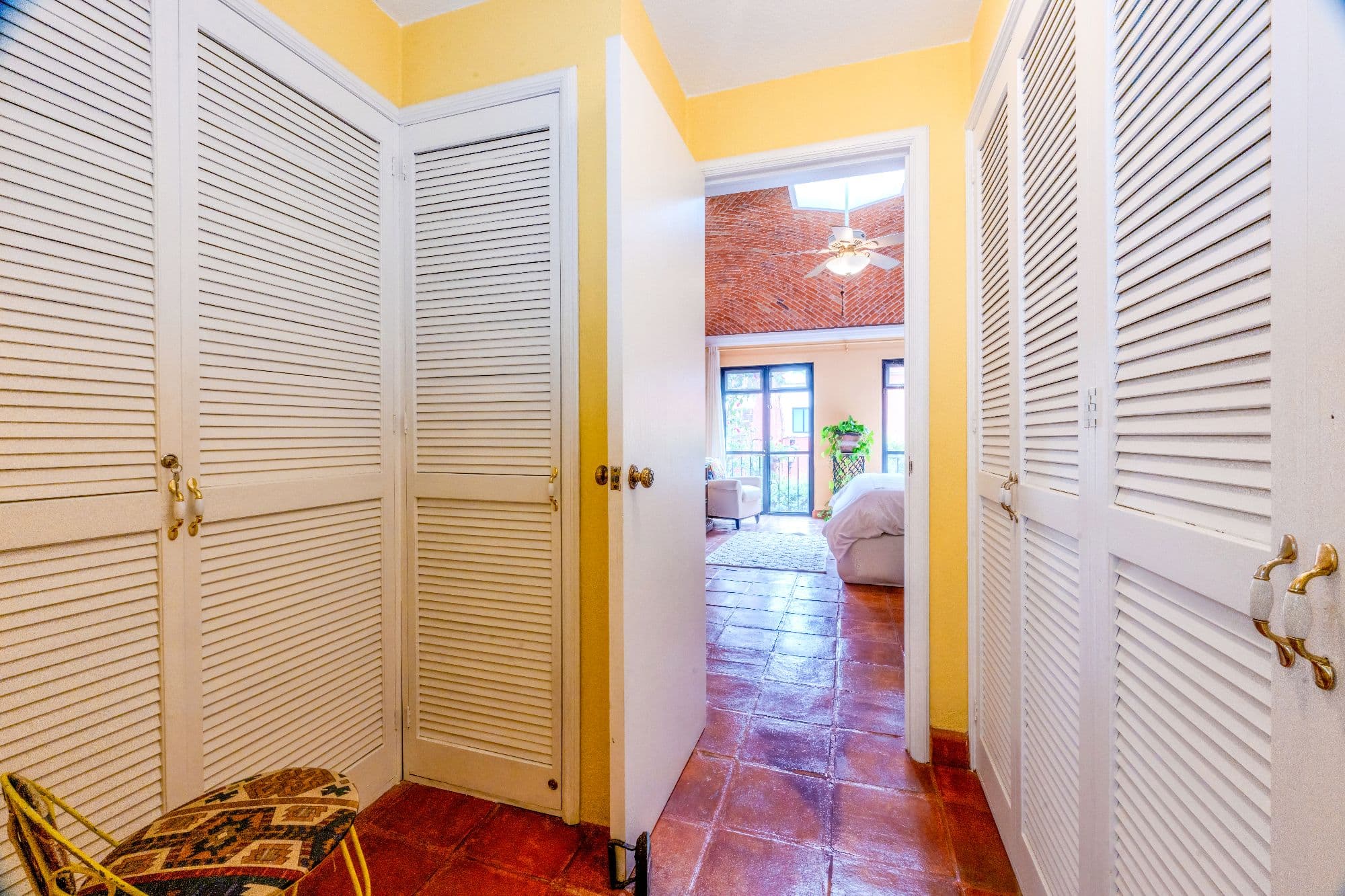Casa De Las Máscaras — Atascadero (Arcos de San Miguel), San Miguel de Allende — photo 23 — bright hallway, charming louvered doors, vibrant accents