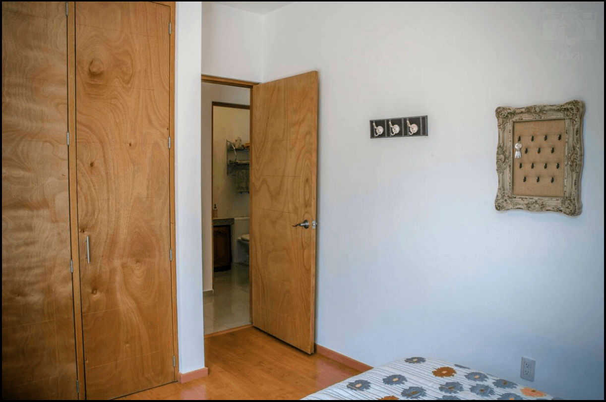 Casa Garzas — Las Brisas, San Miguel de Allende — photo 18 — warm wood doors, bright minimal bedroom