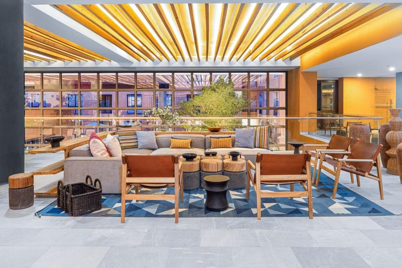 Clevia Apartment — Centro, San Miguel de Allende — photo 5 — sunlit contemporary lounge with golden architecture