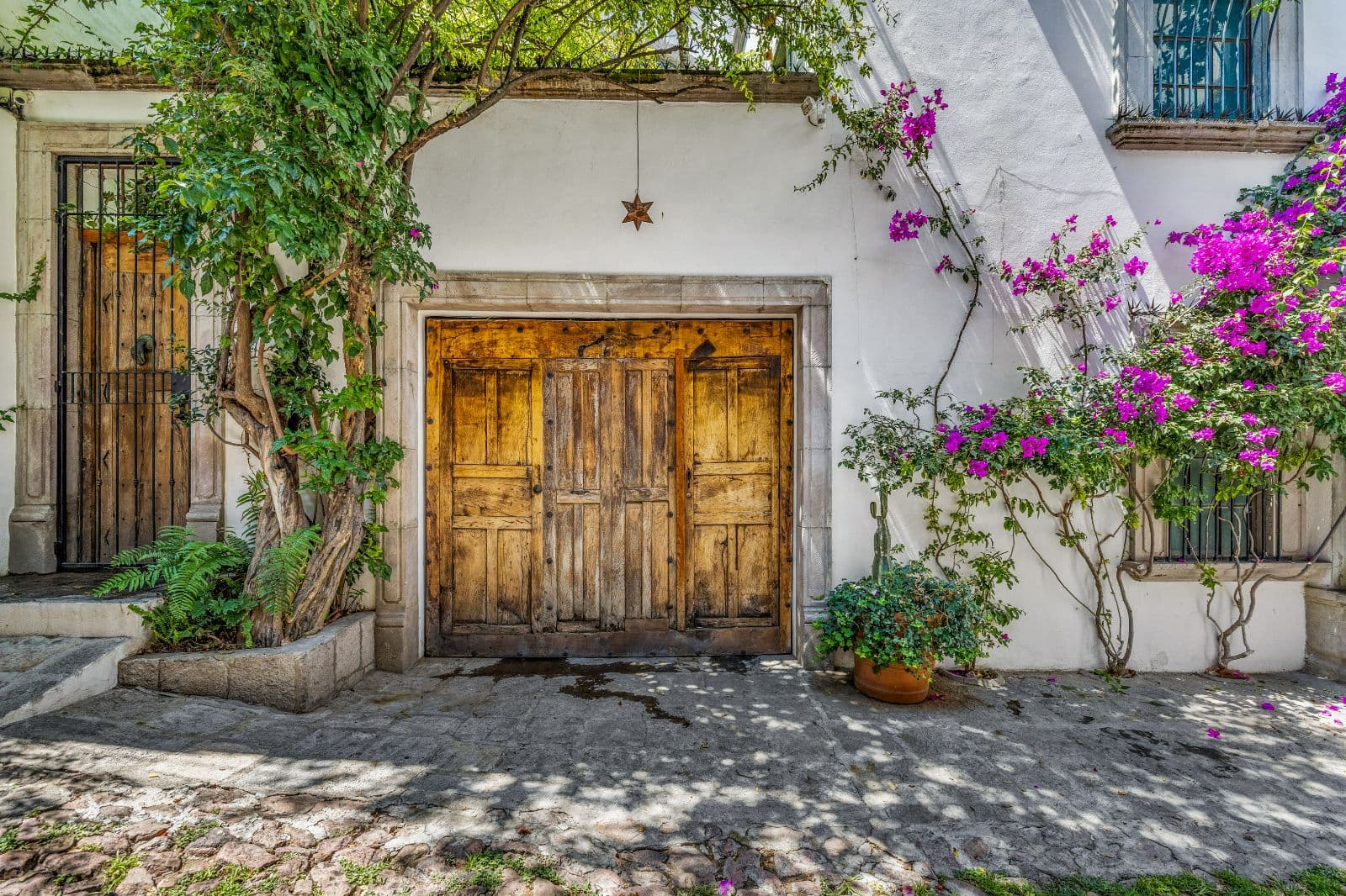 Casa Clae — Guadiana, San Miguel de Allende — photo 6 — charming courtyard, rustic wooden doors, vibrant bougainvillea