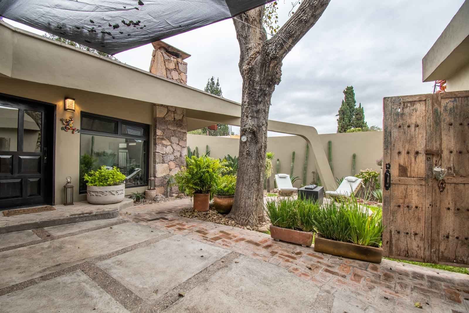 Casa Vista del Cielo — Atascadero (Arcos de San Miguel), San Miguel de Allende — photo 15 — serene courtyard, mature shade tree, architectural charm