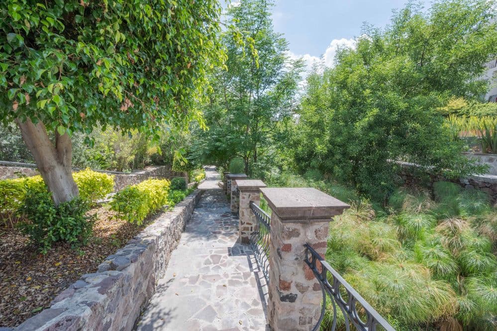 Casa Huerta La Antigua — Antigua Residencial, San Miguel de Allende — photo 27 — serene stone pathways, verdant mature gardens