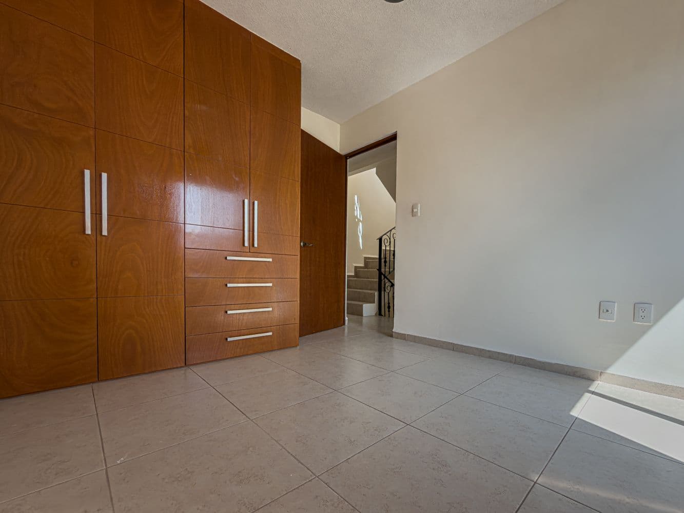 Casa Terracota — Zirándaro, San Miguel de Allende — photo 16 — spacious bedroom with elegant wood cabinetry