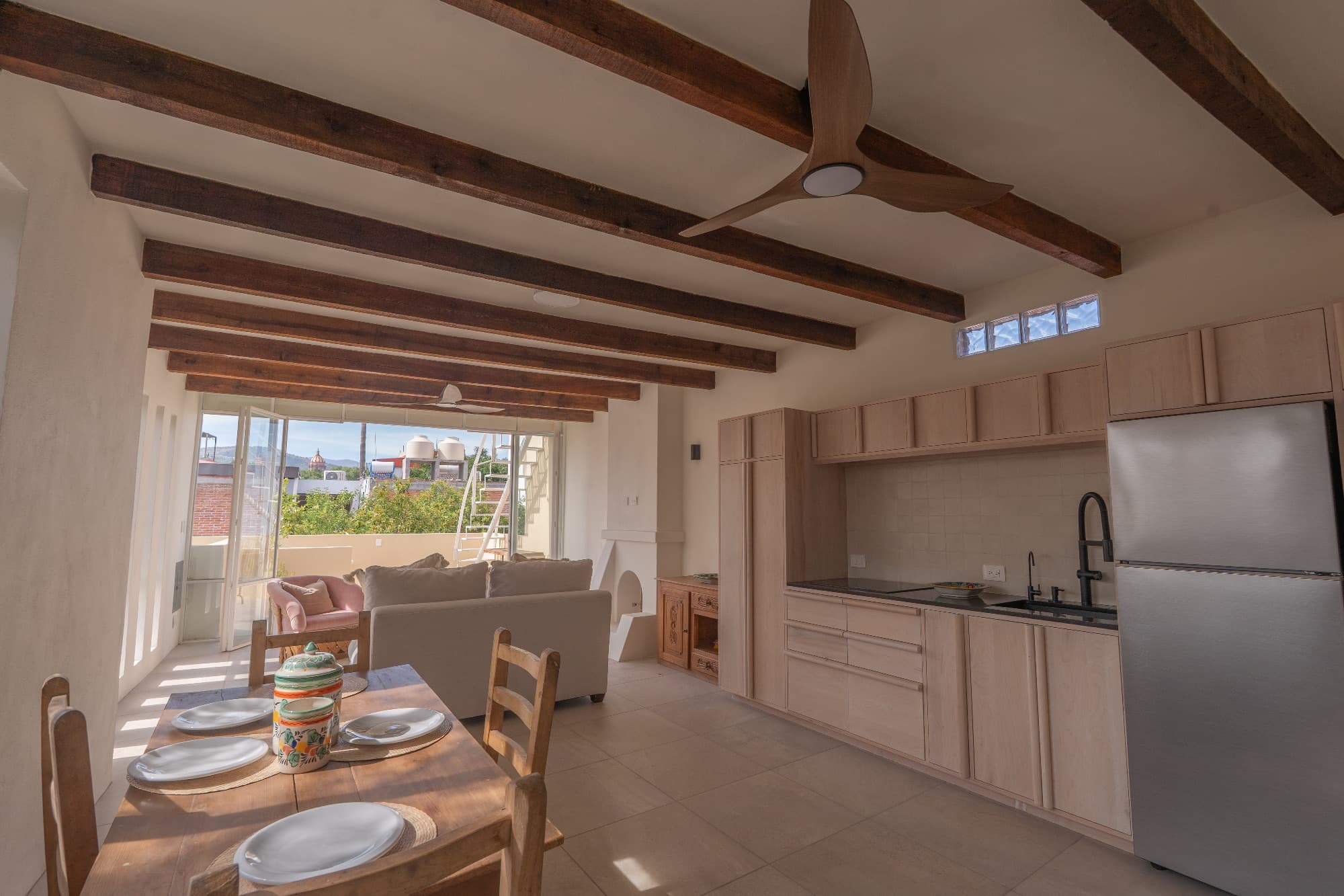 Condo del Sol — Guadalupe, San Miguel de Allende — photo 2 — sunlit open-plan living, exposed beam elegance