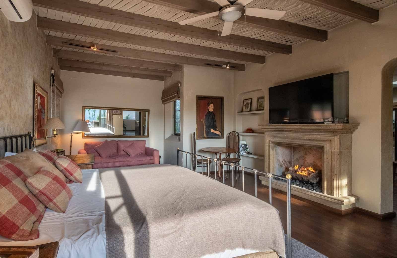 Villa Pirúl — Centro, San Miguel de Allende — photo 18 — rustic-chic master suite with fireplace
