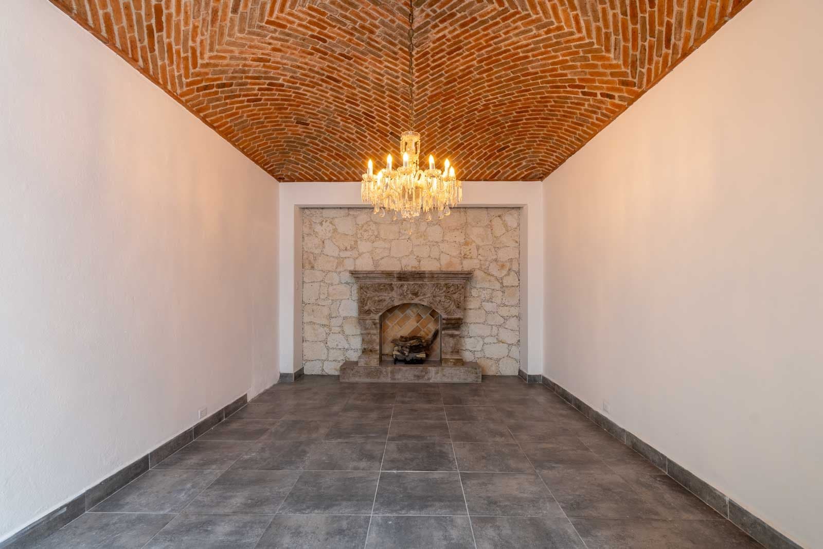 Casa Luz del Sol — Balcones, San Miguel de Allende — photo 10 — elegant fireplace, soaring brick ceiling