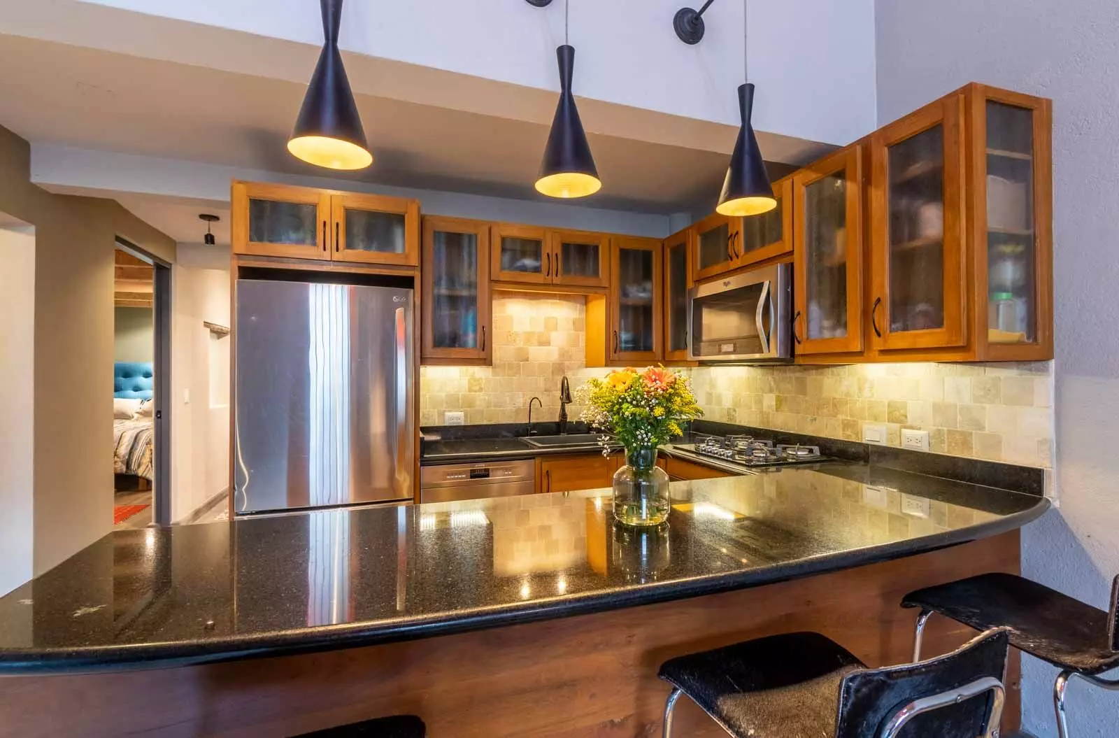 Casa Lumina — Ojo de Agua, San Miguel de Allende — photo 2 — warm wood cabinetry, elegant entertaining kitchen
