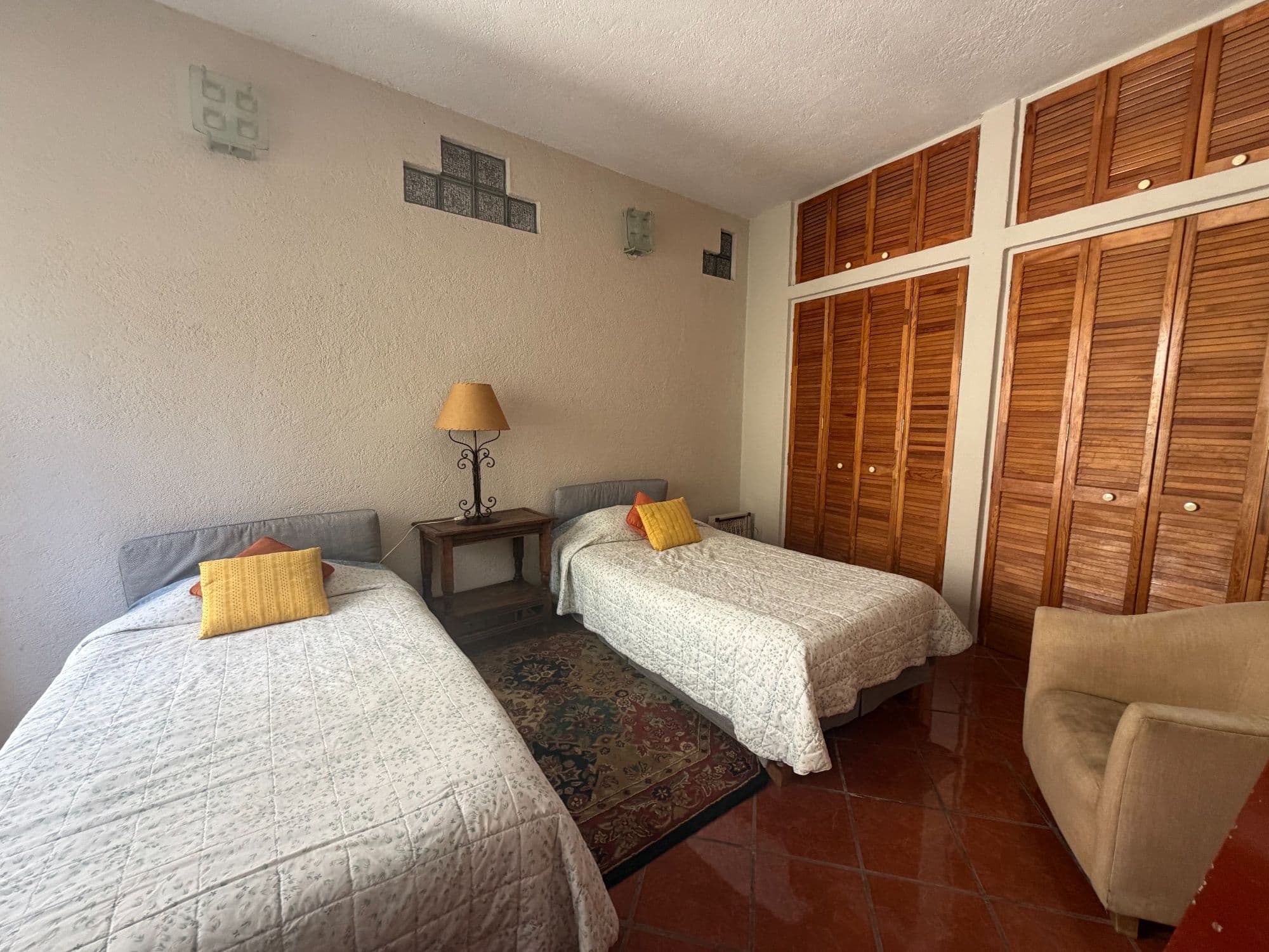 Casa Clinton — Caracol, San Miguel de Allende — photo 22 — spacious guest room, warm wood cabinetry