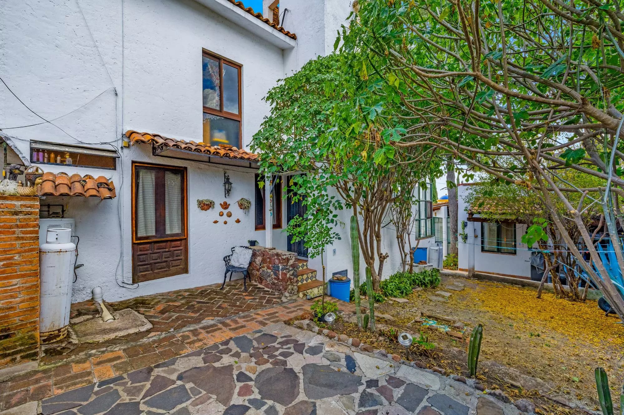 The Hidden House — Rinconada de Los Balcones, San Miguel de Allende — photo 4 — charming courtyard with mature garden canopy