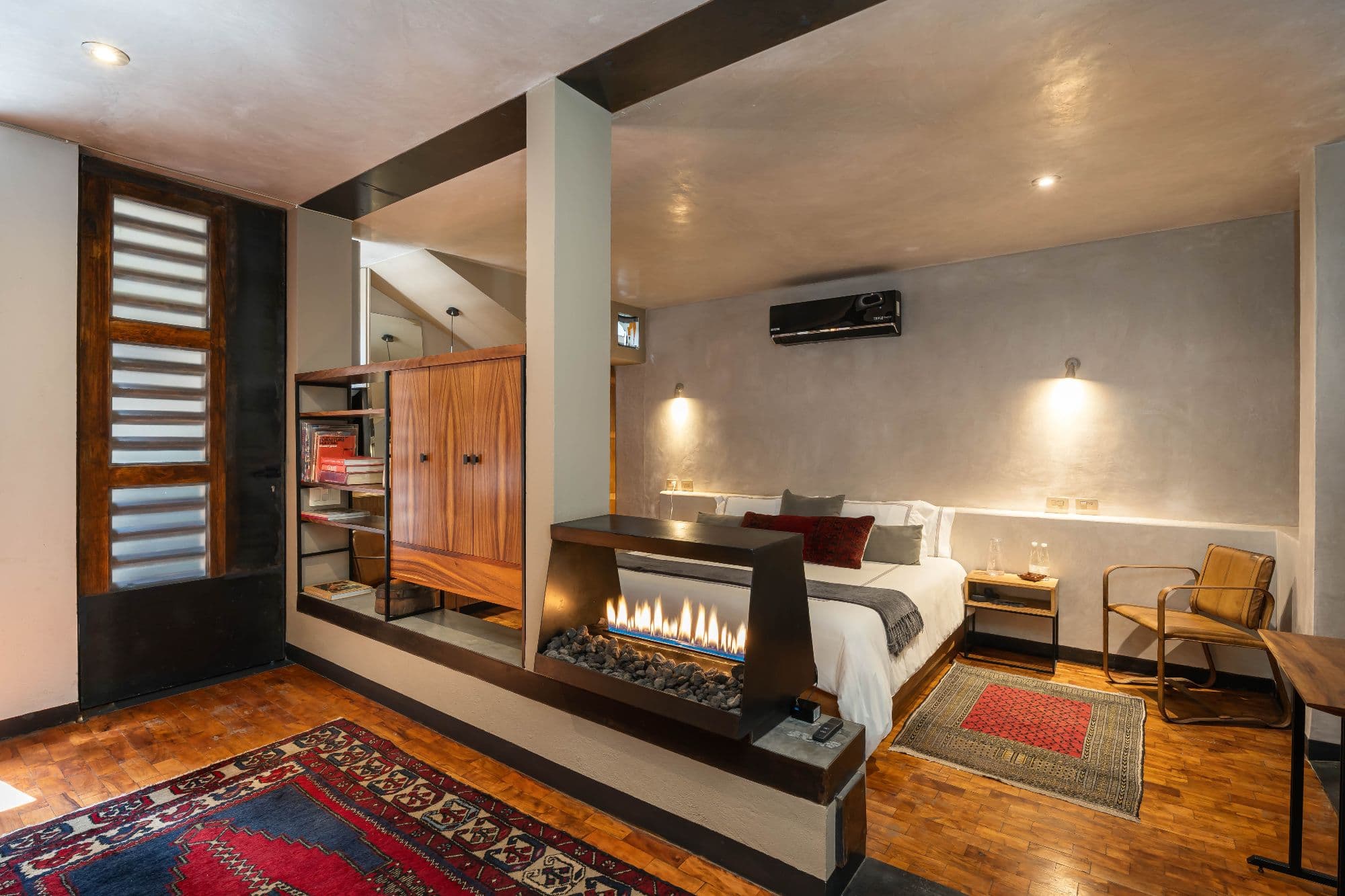 The Lofts — Centro, San Miguel de Allende — photo 12 — contemporary luxury bedroom with statement fireplace
