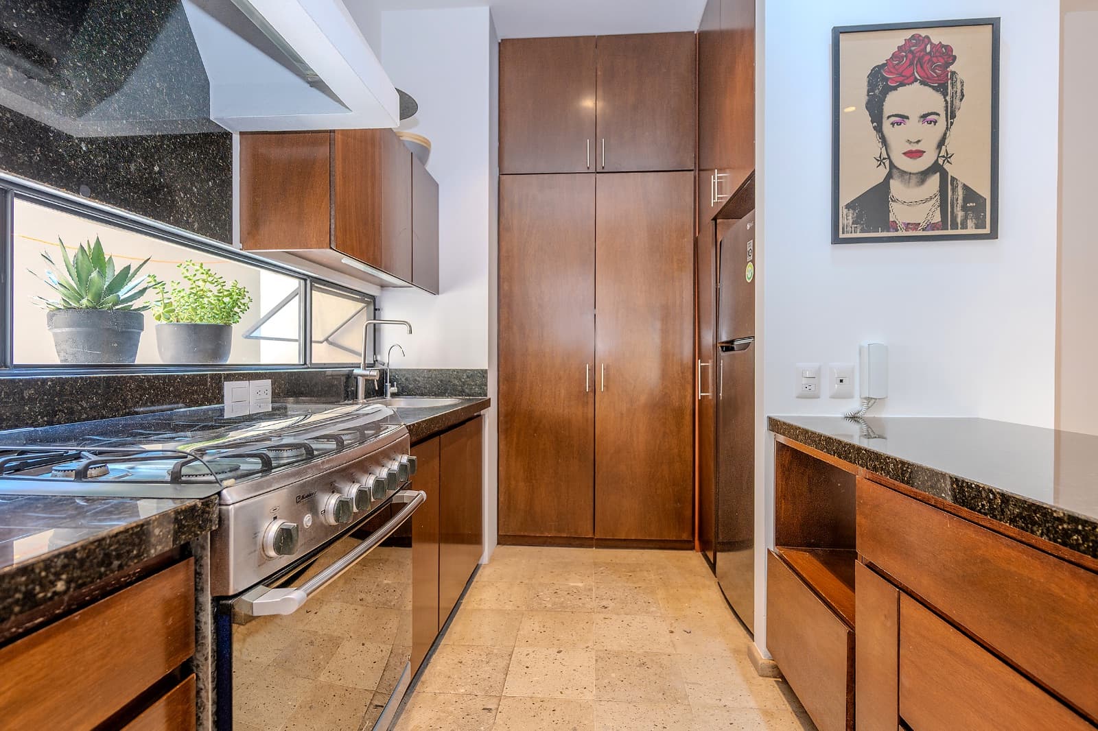 Modern Ground-Level Condo Near Centro — San Antonio, San Miguel de Allende — photo 17 — elegant galley kitchen, warm wood cabinetry