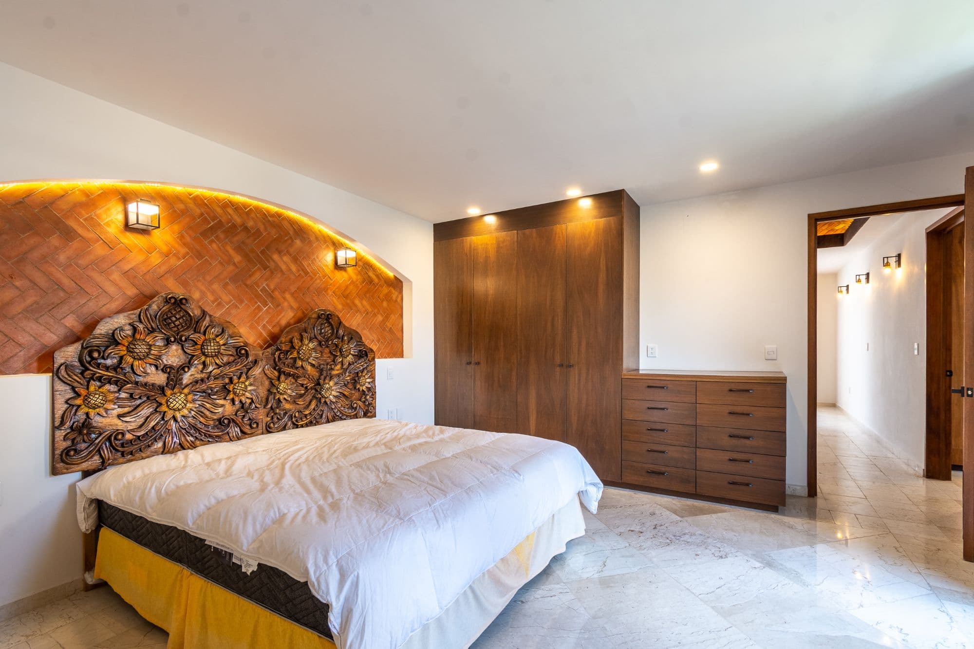 CASA PACO — San Antonio, San Miguel de Allende — photo 13 — artisan-carved headboard, warmly illuminated luxury