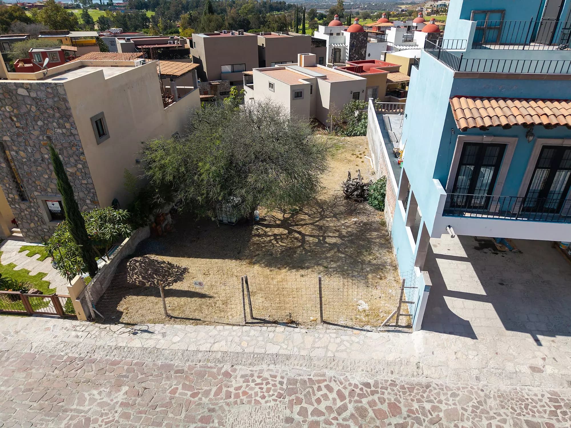 LOT ORIENTE — El Capricho, San Miguel de Allende — photo 7 — sun-drenched courtyard with mature landscaping