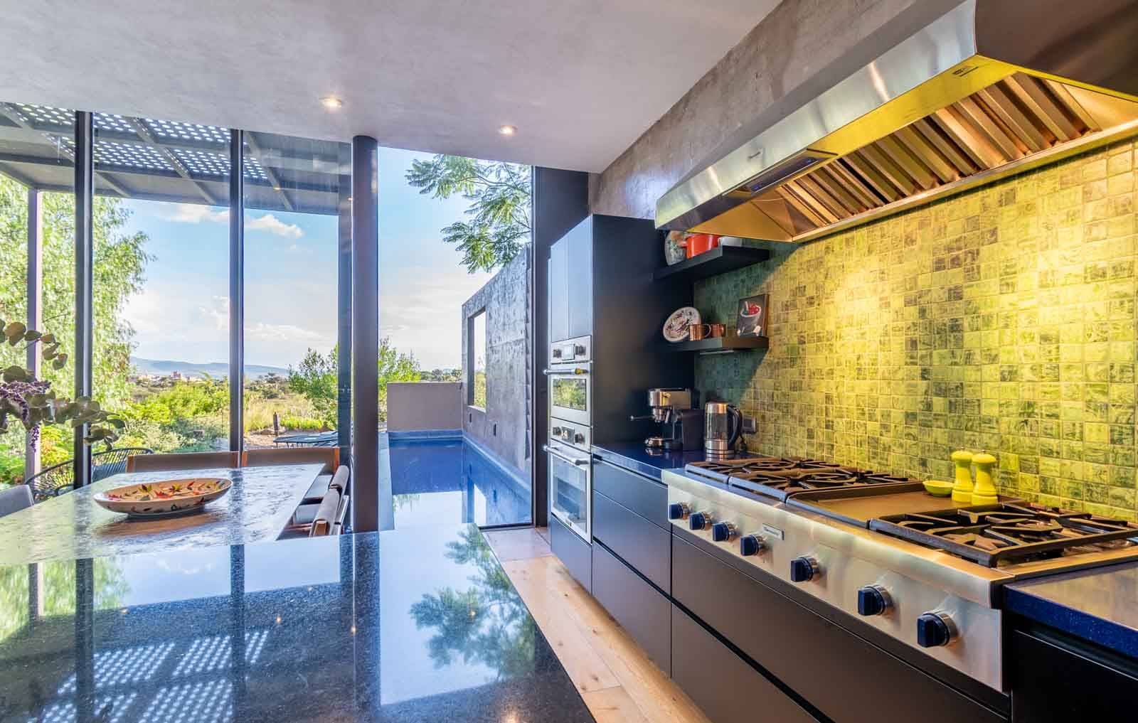 Casa Montolea — Los Senderos, Valle de los, San Miguel de Allende — photo 9 — modern luxury kitchen overlooking pool vista